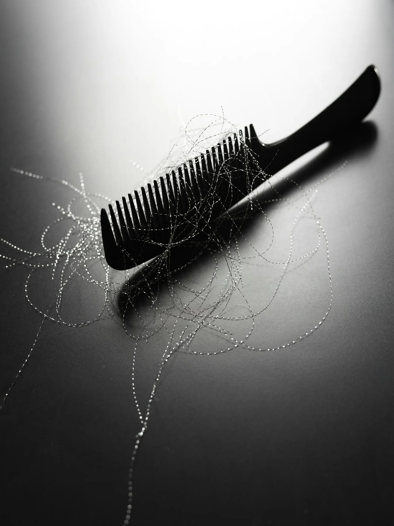 Kamm mit Haarsträhnen auf einer hellen Oberfläche