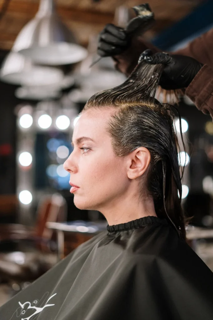 Haarfarbe wird mit einem Pinsel auf eine abgeteilte Haarsträhne aufgetragen