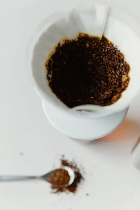 Feuchter Kaffeesatz im Papierfilter eines weißen Kaffeefilters