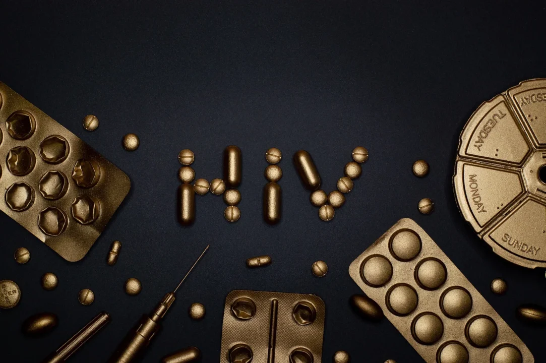 Symbolmotiv mit Tabletten und den Buchstaben HIV