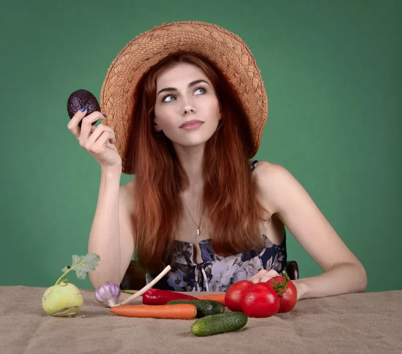 Frau mit Hut an einem Tisch mit Obst