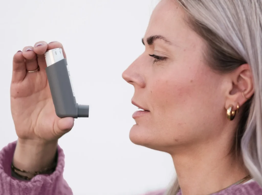 Frau hält einen Inhalator vor den Mund