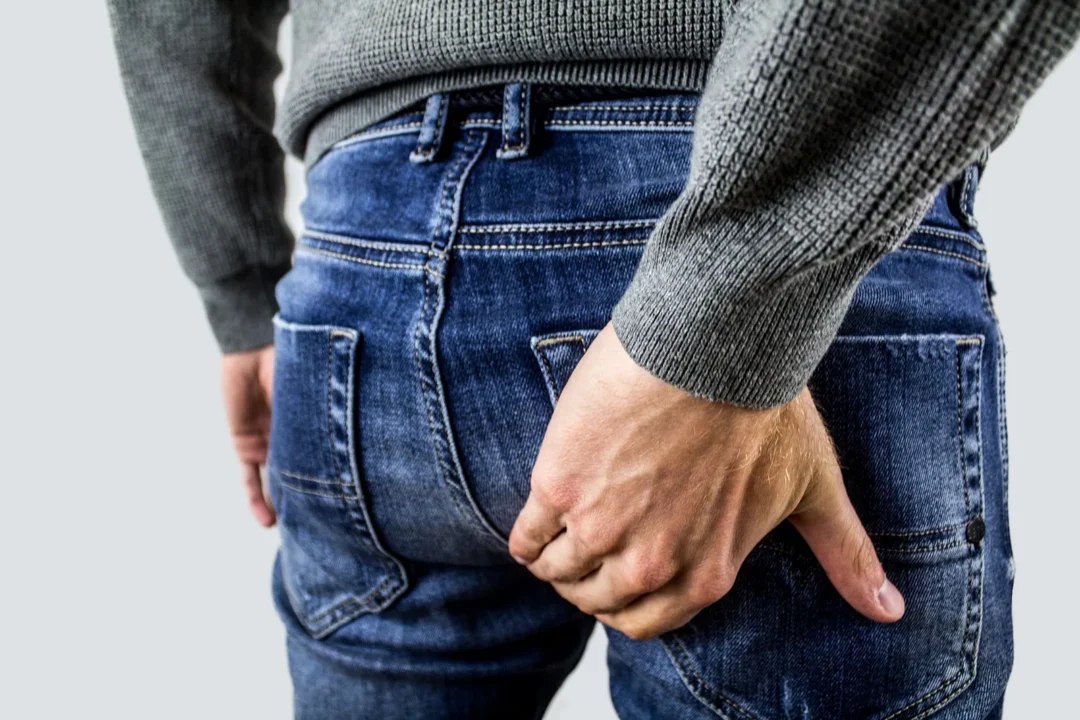 Person berührt den unteren Rücken und die Hosentasche