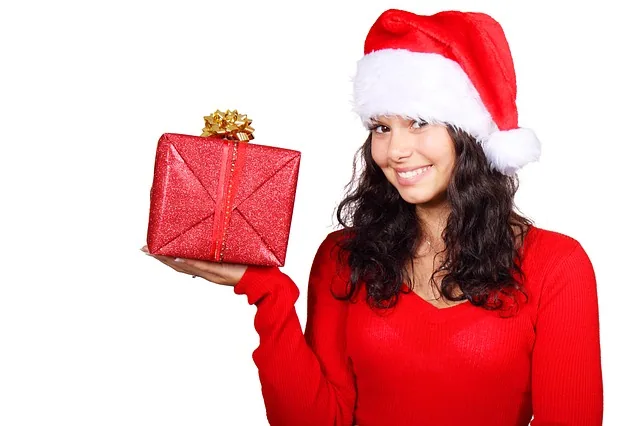 Frau mit Weihnachtsmütze und Geschenkpaket
