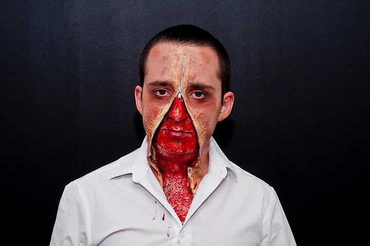 Halloween-Schminke mit einer künstlichen Wunde im Gesicht