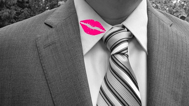 Symbolmotiv eines Hemdkragens mit einem pinkfarbenen Lippenabdruck