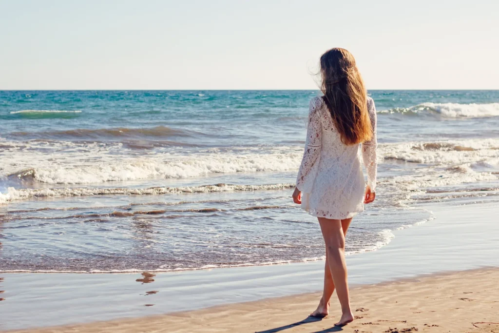 Frau geht am Strand entlang