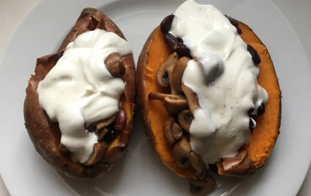 Gebackene Süßkartoffelhälften mit Pilzen und heller Sauce