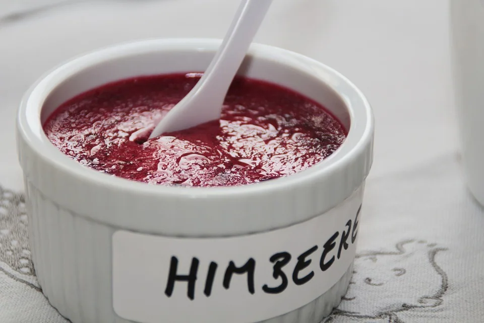 Rote Eismasse in einem beschrifteten Becher mit Löffel