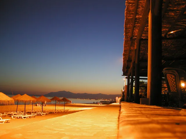 Strandpromenade mit Palmen bei Sonnenuntergang
