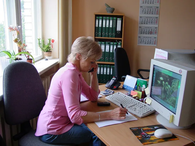 Frau arbeitet an einem Schreibtisch mit Computer