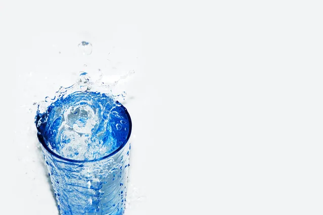 Wasser spritzt aus einem gefüllten Glas