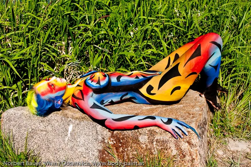 Künstlerisches Bodypainting mit bunten Flammenmotiven