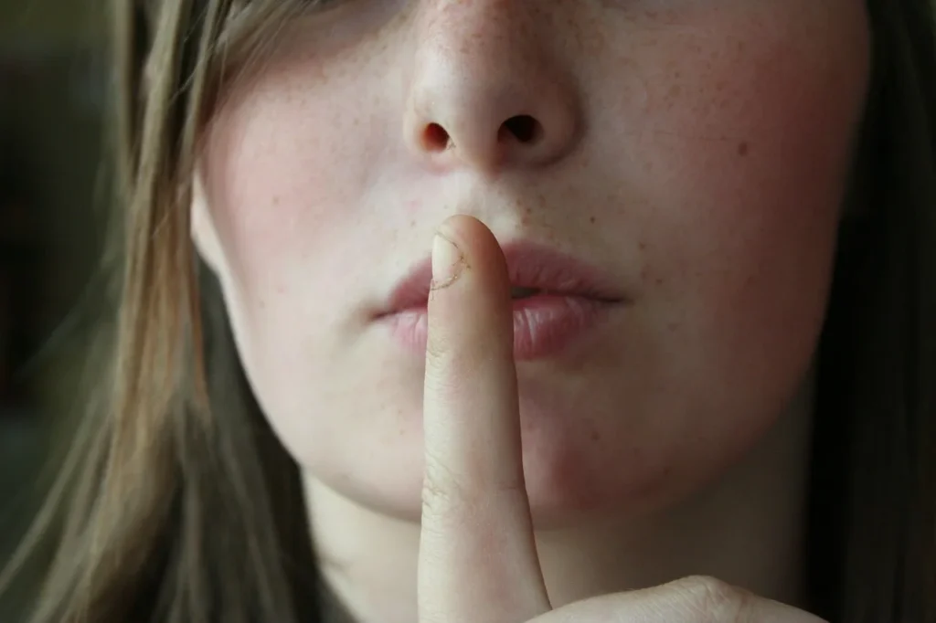 Porträt mit einem Finger vor den Lippen